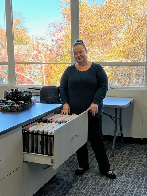 Local California office worker in front of filing cabinet